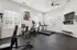 Bright and modern fitness center featuring state-of-the-art treadmills, a stationary bike, and ample natural light, perfect for an energizing workout.