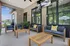 Chic covered patio with stylish outdoor seating, ceiling fan, and lush greenery, offering a serene retreat for relaxation.