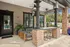 Inviting outdoor patio with modern seating, chic brick pillars, and lush greenery, perfect for relaxation and entertainment.