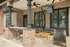 Elegant outdoor patio featuring cozy seating, brick columns, and a sleek bar area, perfect for leisure and entertaining.