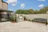 Inviting outdoor space with a modern grill, elegant bench, and lush greenery, perfect for entertaining under the open sky.