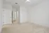 Bright and inviting bedroom with plush carpeting and open closet access, perfect for personal retreat.