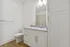 Modern bathroom featuring sleek white cabinetry, elegant granite countertop, and polished chrome fixtures, creating a bright, inviting space.