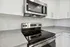 Modern kitchen with sleek stainless steel appliances, granite countertops, and elegant white cabinetry.