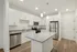 Modern kitchen with sleek white cabinets, stainless steel appliances, and a chic granite island, perfect for culinary enthusiasts.