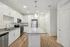 Bright and modern kitchen with sleek stainless steel appliances, elegant granite countertops, and stylish white cabinetry exuding contemporary charm.