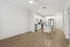 Modern open-concept kitchen with sleek stainless steel appliances, elegant white cabinetry, and warm wood-tone flooring.