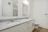 Elegant bathroom with dual sinks, granite countertops, and modern fixtures, offering a sleek and refreshing space.