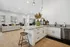 Chic open-concept kitchen and living area featuring elegant countertops, modern lighting, and cozy seating with vibrant cushions.