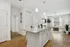 Bright, modern open-concept living space featuring a chic kitchen island, cozy living room with natural light, and elegant wood flooring.