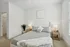 Elegant bedroom with a plush gray bed, modern nightstands, and soft lighting, offering a serene and tranquil retreat.
