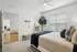 Inviting bedroom with elegant decor, featuring a plush bed, cozy textiles, and abundant natural light, perfect for relaxation.