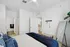 Modern bedroom with elegant decor, featuring a cozy bed, sleek mirror, and stylish accents.