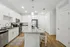 Modern kitchen with sleek white cabinetry, stainless steel appliances, and elegant countertop island with seating.