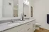 Luxurious bathroom featuring a sleek double vanity with granite countertop, modern fixtures, and elegant decor.