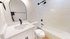 Elegant bathroom showcasing a modern white sink, sleek black fixtures, and a pristine shower-bath combo for a luxurious experience.