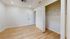 Inviting bedroom with elegant wood flooring, spacious closet, and modern ceiling fan for a comfortable living experience.