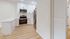 Modern kitchen with sleek stainless steel appliances, elegant white cabinetry, and warm wooden flooring, offering a stylish and functional space.