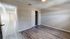 Bright and airy bedroom with stylish wood flooring and ample closet space, leading to an inviting hallway.