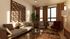 Inviting living room with modern decor, featuring a cozy sofa, chic wall art, and abundant natural light through large windows.