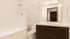 Elegant bathroom with marble walls, modern vanity, and a sleek white bathtub, exuding luxury and style.