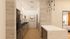 Modern kitchen with sleek gray cabinets, marble countertops, and artistic decor next to a cozy bedroom in a stylish apartment.