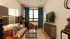 Chic and cozy living room with elegant decor, featuring a stylish sofa, vibrant armchair, and large windows for ample natural light.