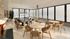 Elegant dining area with modern table and chairs, featuring floor-to-ceiling windows and sleek pendant lighting.
