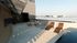 Luxurious rooftop terrace with stylish lounge chairs, modern parasols, and a cozy seating area, perfect for enjoying sunny days.