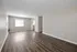 Spacious open-concept living area with natural light and sleek hardwood floors, perfect for modern living.