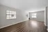 Spacious and bright living room with elegant wood flooring, large windows, and fresh neutral walls.