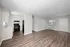 Bright open-concept living space with modern kitchen, featuring sleek appliances and elegant hardwood flooring.