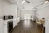Sleek modern interior with elegant white cabinetry, gleaming wood floors, and ample natural light through double French doors.