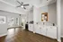 Bright and modern open-concept entryway featuring stylish cabinetry, sleek countertops, and elegant wood flooring, perfect for a welcoming living space.