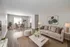 Inviting living room with cozy beige couches, elegant coffee table, and a chic dining area, offering ample natural light and modern decor.