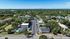 Aerial view of a charming residential area with lush greenery, well-maintained roads, and a sparkling pool inviting relaxation.