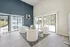 Bright and modern living area with sleek white chairs and expansive windows overlooking a pool oasis.