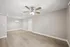 Bright open-concept living area with elegant ceiling fan and modern light fixture, featuring stylish wood flooring and neutral wall tones.
