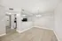 Modern open-plan space featuring a cozy dining area with elegant lighting and a sleek kitchen with black appliances.