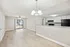 Inviting open-concept living area with elegant wood flooring, modern lighting, and a sleek kitchen perfect for entertaining.