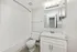 Chic modern bathroom with sleek white fixtures, elegant vanity, and contemporary lighting.