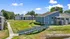 Charming blue apartment buildings with modern design, surrounded by lush greenery and scenic pathways.