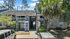 Charming apartment exterior with lush palm trees, ample parking, and welcoming ambiance in a serene setting.