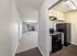 Bright open-plan apartment with stylish kitchen, modern appliances, and spacious living area leading to a sunny balcony.