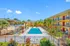 Vibrant apartment community featuring a luxurious outdoor pool, surrounded by lush tropical landscaping and modern amenities.