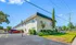 Charming apartment building with lush greenery and ample parking, set in a peaceful neighborhood under clear blue skies.