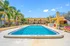 Vibrant apartment community featuring a luxurious outdoor pool, surrounded by lush tropical landscaping and modern amenities.