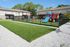 Charming apartment complex playground featuring colorful slides and swings on a lush green lawn, perfect for family fun.