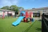 Inviting playground with vibrant slides and swings set against lush greenery, ideal for family-friendly living.
