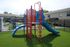 Vibrant playground with colorful slides and climbing structures on lush green turf, perfect for family-friendly living.